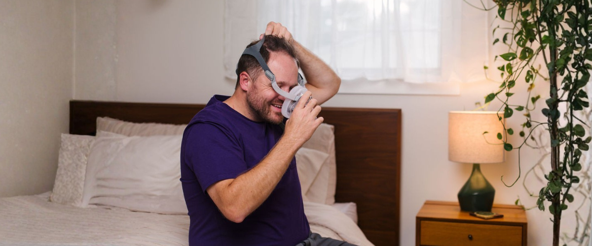 Best CPAP Masks for Beards Person with a beard with sleep apnea trying on a full CPAP mask to treat his obstructive sleep apnea