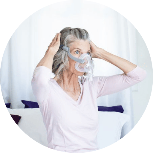 sleep apnea patient putting on a full face cpap mask