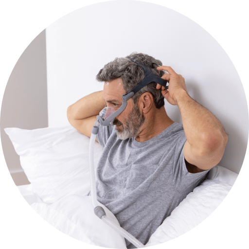man putting on a nasal cpap mask for sleep apnea treatment
