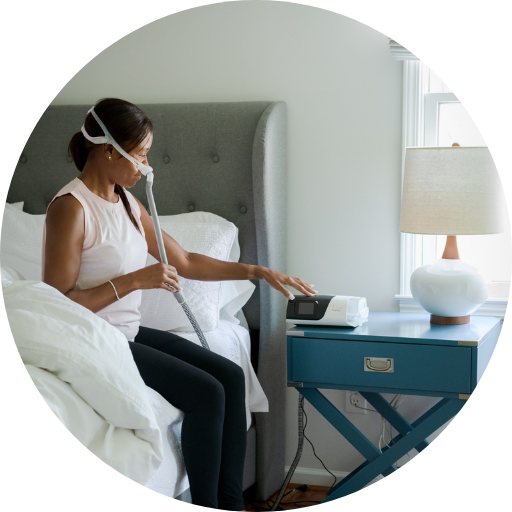 woman wearing a nasal cpap mask and turning on a cpap machine