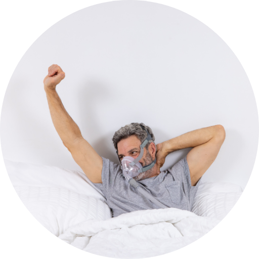 man waking up comfortably wearing a full face CPAP mask after a night of CPAP treatment