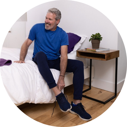 man putting on running shoes and wearing exercise clothes