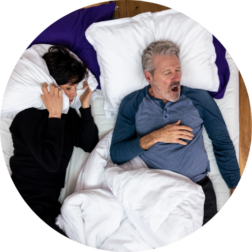 Couple in bed struggling to sleep due to sleep apnea