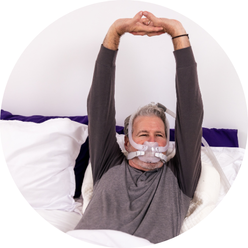 Man with a beard wearing a full face CPAP mask waking up after using CPAP therapy for his sleep apnea