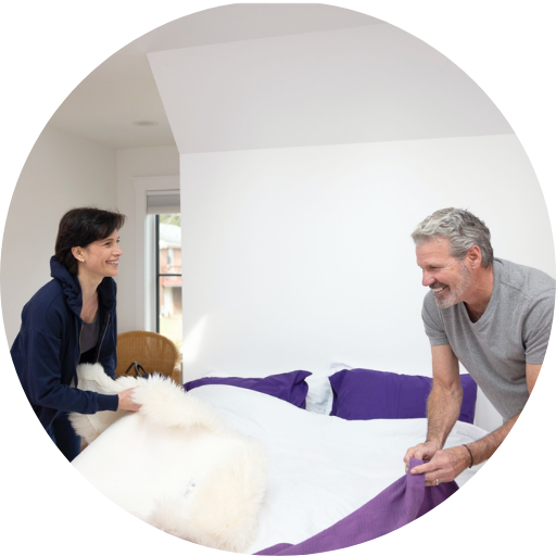 couple happily making the bed together