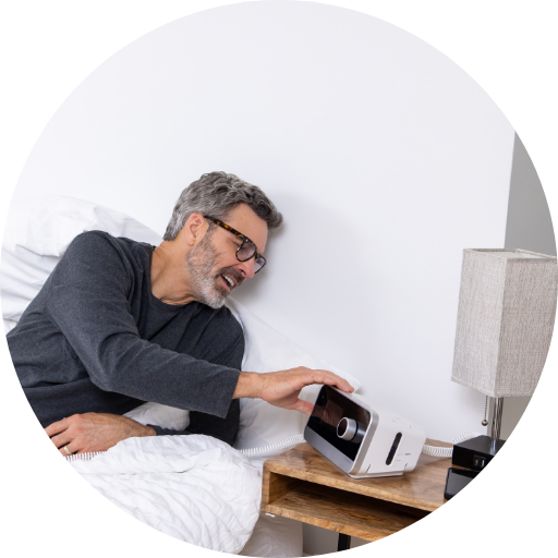 man adjusting machine pressure settings on his resmed cpap machine he uses to treat sleep apnea