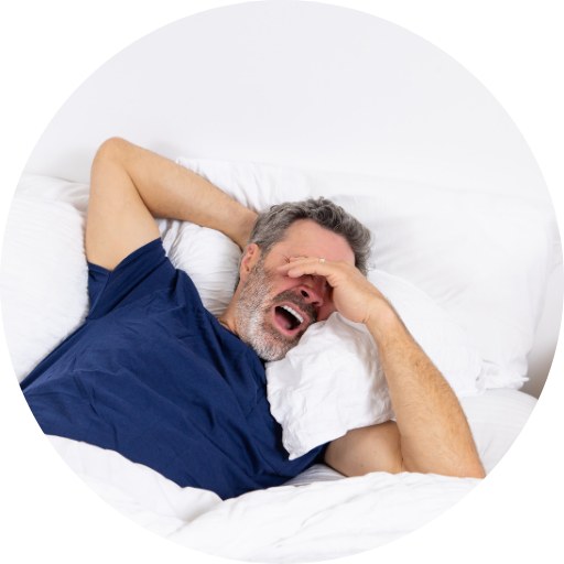 man in bed struggling to sleep and yawning