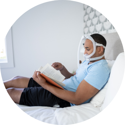 Man in bed wearing a full face CPAP mask