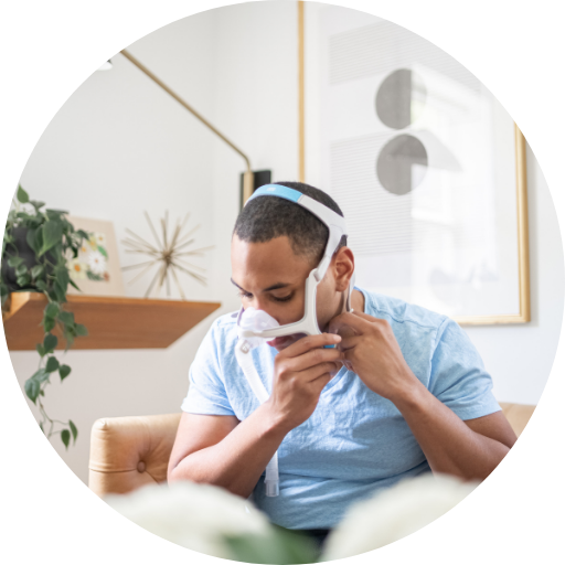 man putting on a nasal CPAP mask