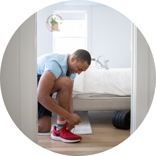 man putting on tennis shoes to go exercise
