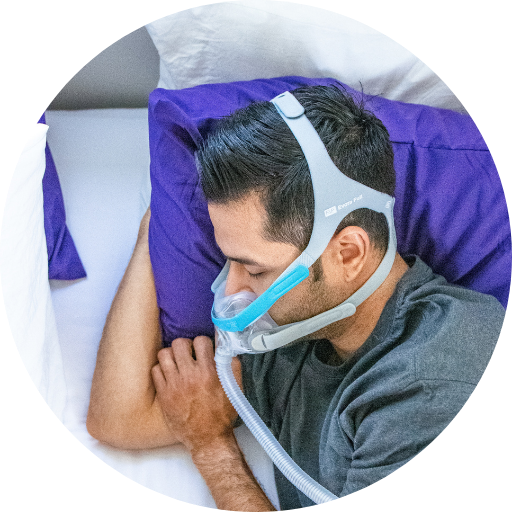 man sleeping on his side wearing a full face cpap mask for his sleep apnea