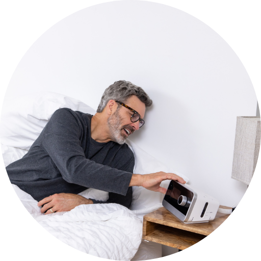 man turning on a cpap machine to use for sleep apnea treatment