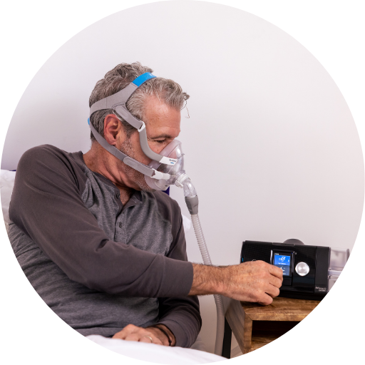 man wearing a full face cpap mask and using a cpap machine