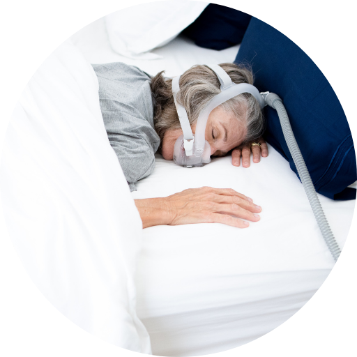 woman sleeping on her stomach while wearing a full face cpap mask