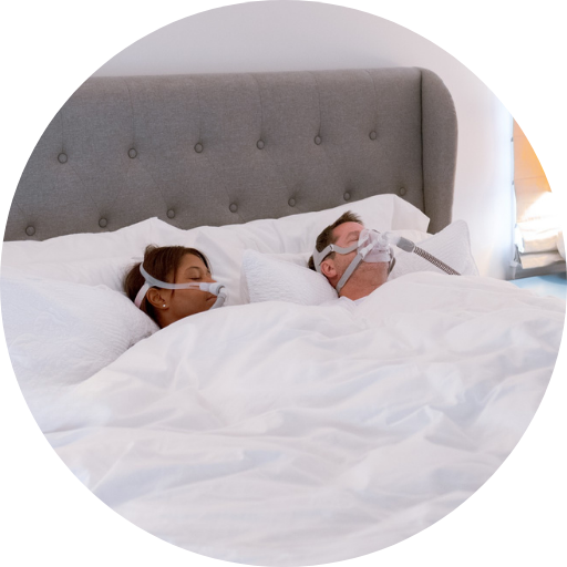 two people sleeping comfortably using cpap masks to treat their sleep apnea